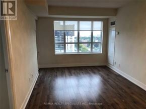 Toronto (Etobicoke West Mall) condo for rent - A room with wooden flooring and a large window overlooking a cityscape.