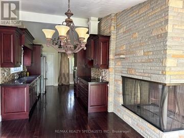 Vaughan (Islington Woods) apartment for rent - A kitchen with dark wood floors and a brick wall.