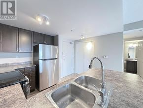 Guelph (Pineridge/Westminster Woods) condo for rent - A kitchen with a sink, refrigerator, and cabinets.