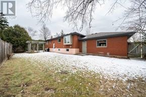 Burlington (Brant) apartment for rent - A red brick house with snow on the ground and trees in the background.