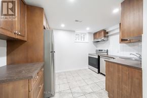 Burlington (Brant) apartment for rent - A kitchen with wooden cabinets and a refrigerator.