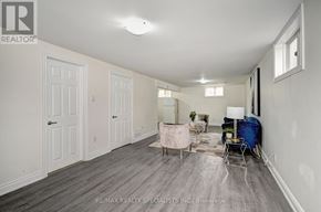 Kitchener apartment for rent - A spacious room with a grey floor and white walls, furnished with a sofa, chair, and table.