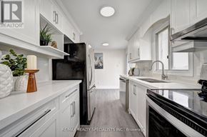Kitchener apartment for rent - A modern kitchen with white cabinets and black appliances.