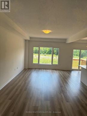 Brant (Paris) townhouse for rent - A room with wooden floors and a large window overlooking a grassy area.