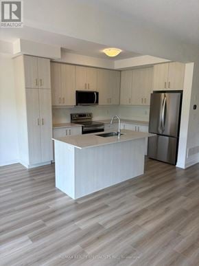 Brant (Paris) townhouse for rent - A modern kitchen with a white island and stainless steel appliances.