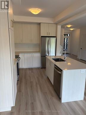 Brant (Paris) townhouse for rent - A kitchen with white cabinets and a wooden floor.