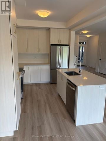 Brant (Paris) townhouse for rent - A kitchen with white cabinets and a wooden floor.
