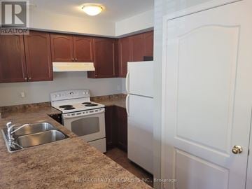 Mississauga (Churchill Meadows) townhouse for rent - A kitchen with brown cabinets and a white refrigerator.