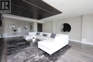 Hamilton (Central) condo for rent - A living room with a white couch and a black and white rug.