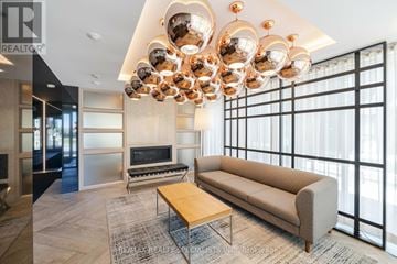 Oakville (Go Glenorchy) condo for rent - A modern living room with a large sectional sofa and a coffee table.