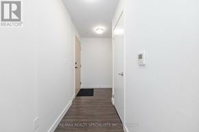 Oakville (Go Glenorchy) condo for rent - A hallway with a door on the right and a mat on the floor.