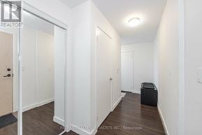 Oakville (Go Glenorchy) condo for rent - A hallway with a door on the left and a black box on the right.