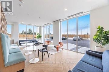 Kitchener condo for rent - A living room with a blue couch and a white table.