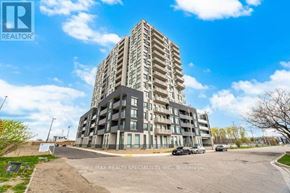 Kitchener condo for rent - A tall residential building with a parking lot in front.