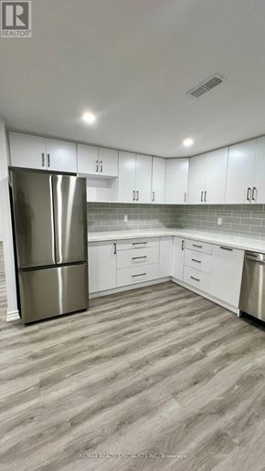 New Tecumseth (Tottenham) apartment for rent - A modern kitchen with a stainless steel refrigerator and white cabinets.