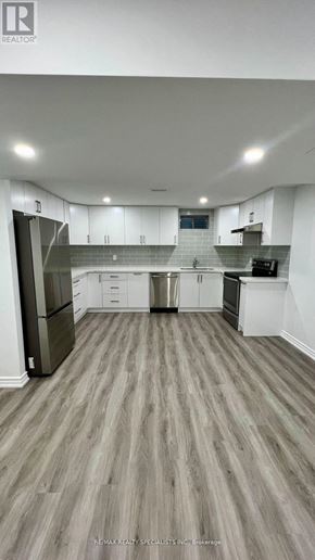New Tecumseth (Tottenham) apartment for rent - A well-lit, modern kitchen with white cabinets and a wooden floor.
