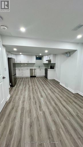 New Tecumseth (Tottenham) apartment for rent - A spacious room with wooden flooring and white walls.