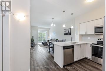 Milton (Wi Willmott) condo for rent - A modern kitchen with white cabinets and stainless steel appliances.