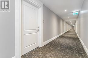 Milton (Wi Willmott) condo for rent - A long hallway with a carpeted floor and white walls.