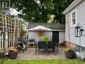 Centre Wellington (Fergus) apartment for rent - A patio with a table and chairs is surrounded by a fence and has a tree in the background.