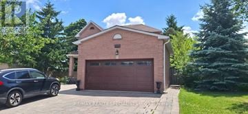 Mississauga (Meadowvale) apartment for rent - A house with a garage and a car parked in front.