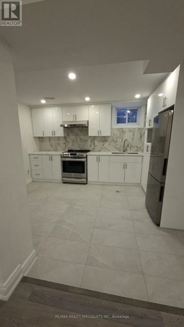Oshawa (Vanier) apartment for rent - A kitchen with white cabinets and a tiled floor.