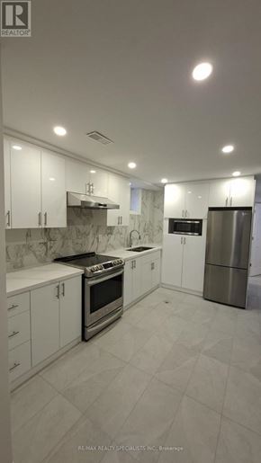 Oshawa (Vanier) apartment for rent - A modern kitchen with white cabinets and stainless steel appliances.