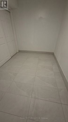 Oshawa (Vanier) apartment for rent - A white tiled room with a Realty logo in the corner.