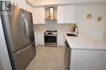 Thorold (Rolling Meadows) townhouse for rent - A kitchen with a stainless steel refrigerator and white cabinets.
