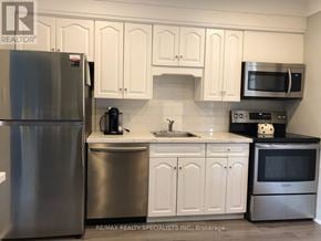 Burlington (Brant) multi-family for rent - A kitchen with white cabinets and a stainless steel refrigerator.