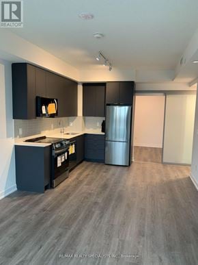 Brampton (Fletcher's Creek South) condo for rent - A modern kitchen with dark brown cabinets and a stainless steel refrigerator.