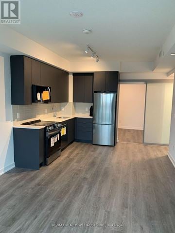 Brampton (Fletcher's Creek South) condo for rent - A modern kitchen with dark brown cabinets and a stainless steel refrigerator.