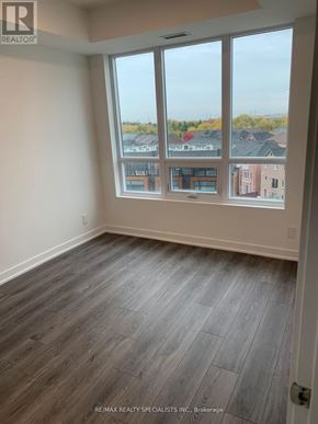 Brampton (Fletcher's Creek South) condo for rent - A room with a large window and a wooden floor.