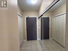 Mississauga (East Credit) condo for rent - A hallway with two doors at the end and a RE/MAX Realty Specialists Inc. sign on the wall.