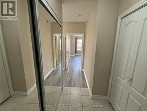 Mississauga (East Credit) condo for rent - A hallway with a white door on the right and a mirror on the left.