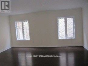 Brampton (Bram East) apartment for rent - A room with two windows and a wooden floor.
