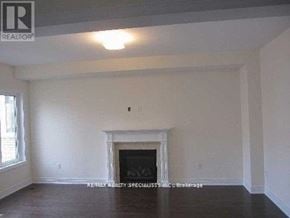 Brampton (Bram East) apartment for rent - A large empty room with a fireplace and wood flooring.