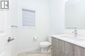 Milton (Walker) apartment for rent - A white bathroom with a toilet, sink, and mirror.