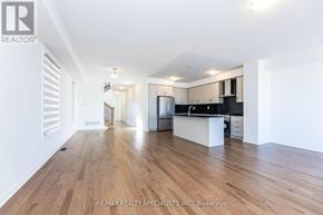 Milton (Walker) apartment for rent - A spacious room with wooden flooring and a kitchen area in the background.