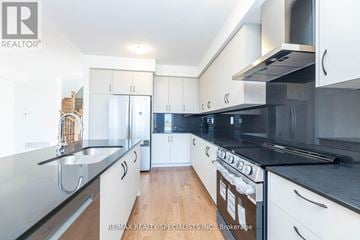 Milton (Walker) apartment for rent - A modern kitchen with white cabinets and black countertops.