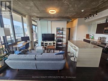 Toronto (Waterfront Communities) condo for rent - A living room with a grey couch and a television.