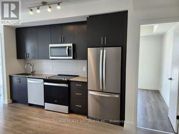 Oakville (Jm Joshua Meadows) condo for rent - A kitchen with black cabinets and stainless steel appliances.