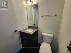 Oakville (Jm Joshua Meadows) condo for rent - A bathroom with a toilet, sink, and mirror.
