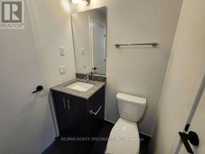 Oakville (Jm Joshua Meadows) condo for rent - A bathroom with a toilet, sink, and mirror.