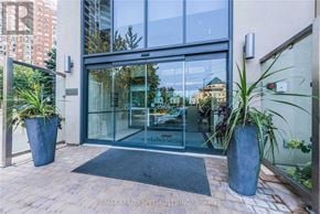 Mississauga (City Centre) condo for rent - The entrance to a building with a glass door and a sign that reads "RE/MAX REALTY SPECIALISTS INC."
