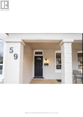 Brantford apartment for rent - A white house with a black door and a number 59 on the wall.