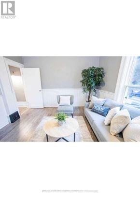 Brantford apartment for rent - A living room with a white sofa and a coffee table with a plant on it.