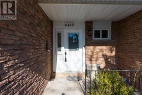 Mississauga (Meadowvale) apartment for rent - The entrance of a building with a white door and a sign that reads "REALTOR".