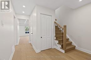 Mississauga (Meadowvale) apartment for rent - A hallway with a white door and a wooden staircase.