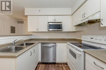 Burlington (Uptown) condo for rent - A kitchen with white cabinets and appliances.